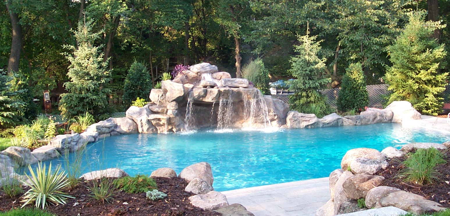Hand sculpted water feature alongside outdoor residential pool.