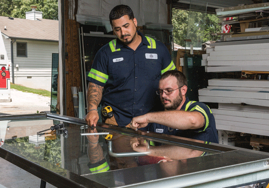 Jorge Medina (left) and Derrick Alderson handle an emergency door repair, which is a part of what Medina Services, Inc. offers to local customers. 