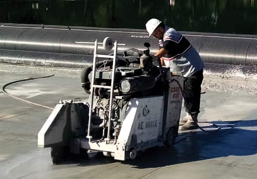 A crew member cuts concrete on the east end of the reflecting pool  at the National Mall in Washington, D.C.