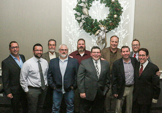 Members of Cain Millwork, Inc.’s leadership team pose for a group photo at the company’s annual Christmas party. Pictured (left to right) are Mike Coticchio, Vice President of Operations; Steve Messer, director of operations; Roger Cain, founder; Chuck Skow, Vice President; Jim Letourneau, shop foreman; Jerry Varner, Vice President of Production; Joe Garvy, CFO; Joe Sebek, Vice President of Sales; Daniel Levin, CEO; and Dr. Jay Levin, chairman.