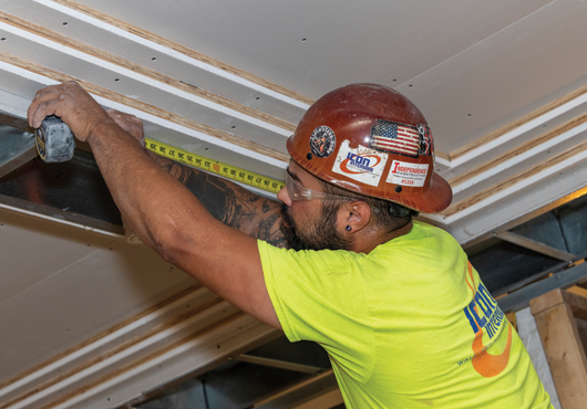 General Foreman Alex Pagan verifies ceiling measurements. The company assigns a foreman to each mid-sized and large project to avoid the miscommunication that can occur when multiple foremen move between job sites.