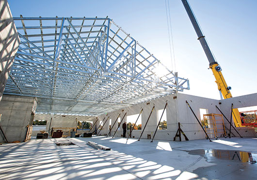A Metro Walls, Inc. crane sets trusses assembled by Atlantic Prefab, Inc. for Shea Concrete in Amesbury, Mass.