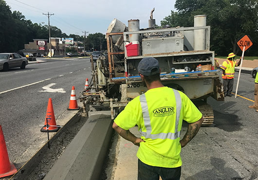 Workers from Anglin Construction Co. oversee the placement of concrete for the median curb along a stretch of Kirkwood Highway in Newark, Del.