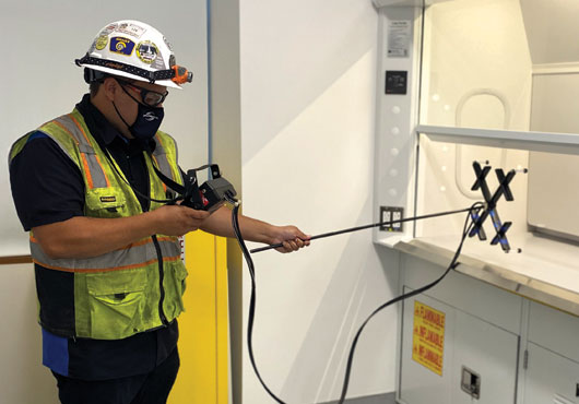 TABB Technician Vincent Granillo uses VelGrid instrumentation from Shortridge Instruments, Inc. to check the airflow velocity of a chemical fume hood.