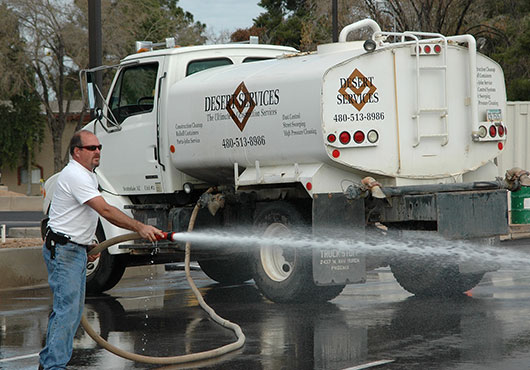 Jim Morrison, Vice President of Field Operations, works the side hose on a lot wash, one of the many services performed by Desert Services.