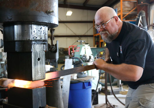 Founder and Principal of Heart of Texas Metalworks LLC, Lee Lanford, forges a part under his company’s 1915 Nazel power hammer.