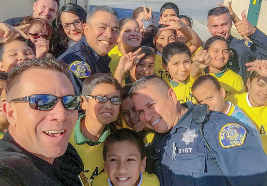 A TEAM Kids graduating class pictured with former San Jose Police Chief Larry Silva, San Jose Police Department (SJPD) officers and Securetech President Anthony Ortega, far left. The TEAM Kids program is taught by SJPD officers, educating youth about drugs and bullying in their community and creating options to make positive choices.