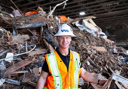 DTG Recycle CEO Tom Vaughn stands in front of new construction and demolition debris. It will be processed through a sorting line to remove recyclable items.