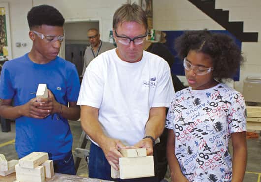 Teacher Duane Renick helps students solve real-world building problems.