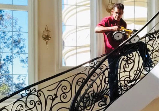 Nildo Bonfim finishes a scroll stair railing, resulting in a unique work of art.