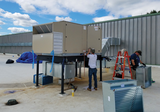 Employees apply new technology to an old HVAC system at EF Academy in New York.