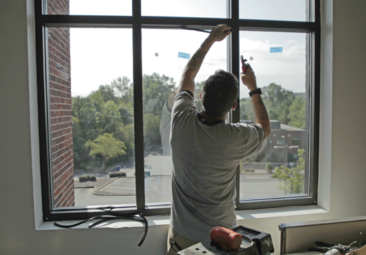 Installer Marcus Mooty runs the gasket in a commercial storefront window system.
