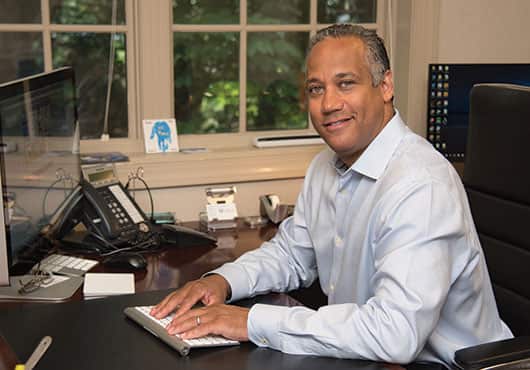André Conway, Owner of Alarm Service Co. of America, Inc., working at his office desk in North Carolina. 