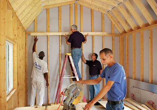 Shown from left to right are George Harris, Lane Dickens, Ted Cashwell and Pete Combs working on the interior of a shed at Whispering Pines Farm.