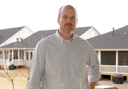 Raleigh Division President Ryan Wells stands outside of a model home in Encore at 12 Oaks in the Holly Springs community.