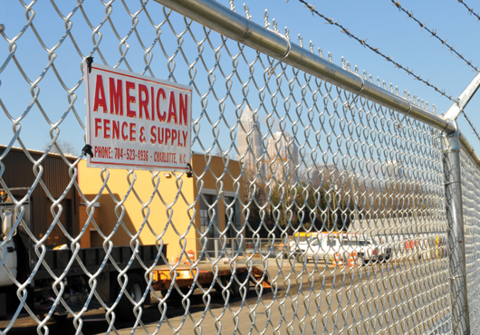 American Fence and Supply Co. has been hanging its sign on fencing it has installed for 50 years. In this photo, an 8-foot chain-link fence is topped with three-strand barbed wire.