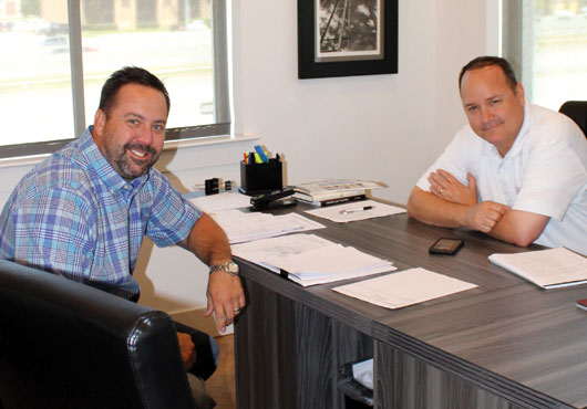 Eric Little, right, CEO of Crimson Building Company, LLC, discusses an upcoming project with Kyle Hege, President.