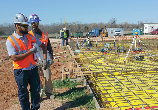 Phillip Parks II (front) and Jamaine Parks Sr. (back) oversee the concrete pour at the Texas Department of Transportation’s maintenance facility in Glen Rose, Texas.