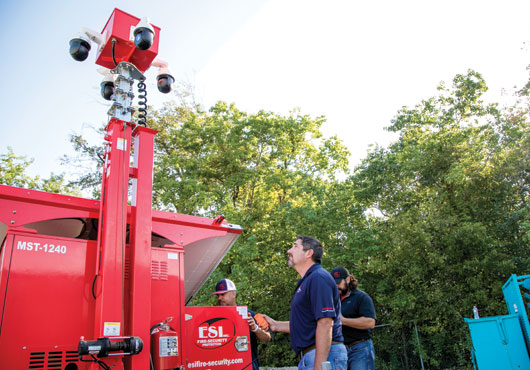 Pictured left to right: Kirk Ellis, Robby Burleson and John Copeland of ESI Fire & Security Protection, Inc. raise the mast and check a live video feed.