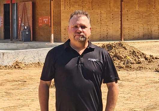 Matt Reyhons, Founder of Integrity Plumbing, LLC, stands in front of the Regal Benders Landing movie theater in Spring, TX. The project totals 124,000 square feet, with 24 auditoriums, including one that is 4DX.