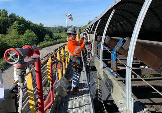 Lead Electrician Brent Williams repairs damaged control circuits on a large Overland conveyor belt in Southwest, Pennsylvania.