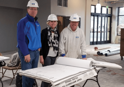 Project Manager Brad Potestio (left), CEO Kristin Anderson (middle), and Superintendent Ed Goff review plans of the College Terrace Market tenant improvement project in Palo Alto, Calif.