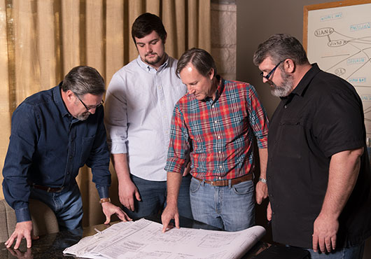 From left to right: Barry Moody, Josh Jacks, Greg Smotherman and Paul Jacks study client plans as they address product installation and scheduling.