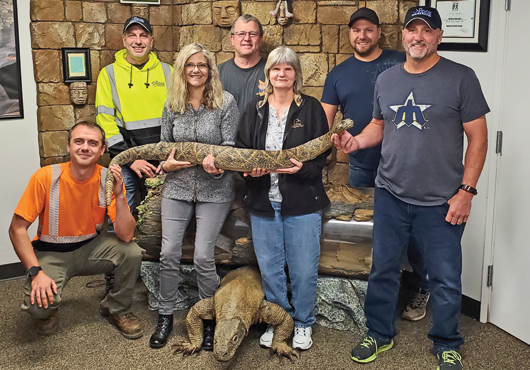 The Edge Concrete Construction LLC management team with the company mascots, Rattler and Komodo. 